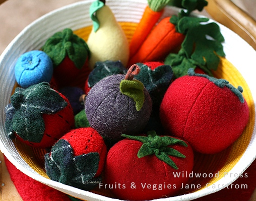 The two strawberries with black stitching are sewn from sweater felt. Boiled wool sweaters aggressively fulled and used as fabric. The other fruits and vegetables are sewn from fulled commercial wool felt. All are stuffed with wool batt.